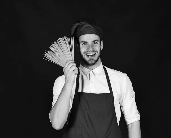 Кухар працює на кухні. Шеф-кухар з усміхнені обличчя тримає купу спагетті — стокове фото