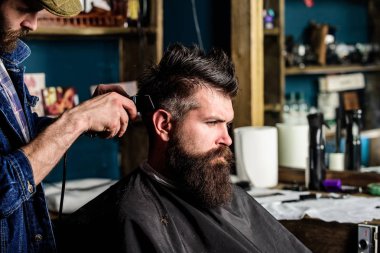 Kuaför saç kesme makinesi ile saç modeli sakallı, berber arka plan için çalışır. Styling saç tarak ve kesme makinesi ile sakallı istemcisinin berber. Saç kesimi kavramı. Hipster istemci Başlarken saç kesimi