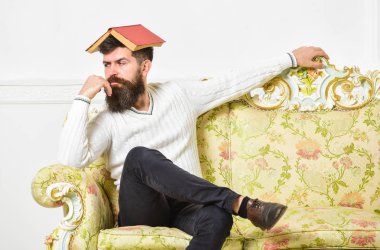 Maço kafasına, çatı gibi açık kitap ile oturuyor. Sıkıcı edebiyat kavramı. Eski sıkıcı kitap okuma fed yukarıya adam sıkılmış. Sakal ve bıyık oturur barok tarzı kanepe, beyaz duvar arka plan üzerinde olan adam