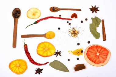 Mutfak sanat kavramı. Baharat ve kuru malzemeyi kaşıklarla bileşimi. Kaşık mutfak otlar ve baharatlar ile dolu. Kaşık mutfak otlar, Yıldız anason ve beyaz zemin üzerine defne yaprağı ile