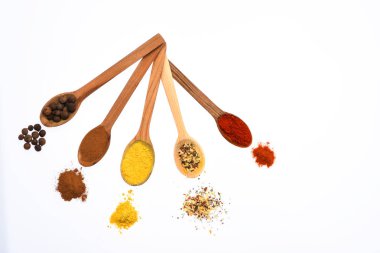 Kaşık mutfak otlar ve baharatlar ile dolu. Kırmızı biber, curcuma ve beyaz zemin üzerine tarçın baharat kaşıklarla. Baharat ve baharat kavramı. Kaşık baharatlar ile yapılmış kompozisyon