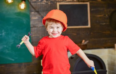 Çocuk Çocuk tamirci oynamak. Çocukluk kavramı. Yürümeye başlayan çocuk kask evde atölye koruyucu sert şapkalı. İngiliz anahtarı ve oyuncak oynarken şirin çocuk gördüm, Oluşturucusu'nu veya repairer, onarımı veya handcrafting