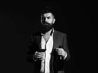 Melul'un sakal ve bordo arka plan üzerinde pahalı alkol ile. Şarapdenemeye, degüstasyon kavramı. Cabernet veya kırmızı şarap ve şişe cam tutan adam