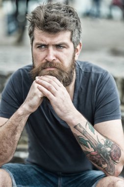 Sakal ve bıyık oturur açık olan adam. Sakallı adam ciddi yüz üzücü ve sorunlu görünüyor, sorunları muzdarip. Zor dönemden geçiyor sakallı hippi. Üzüntü ve sorunları kavramı
