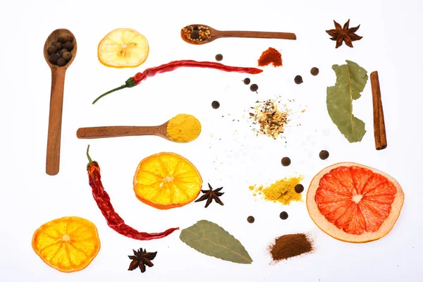 Mutfak sanat kavramı. Baharat ve kuru malzemeyi kaşıklarla bileşimi. Kaşık mutfak otlar ve baharatlar ile dolu. Kaşık mutfak otlar, Yıldız anason ve beyaz zemin üzerine defne yaprağı ile