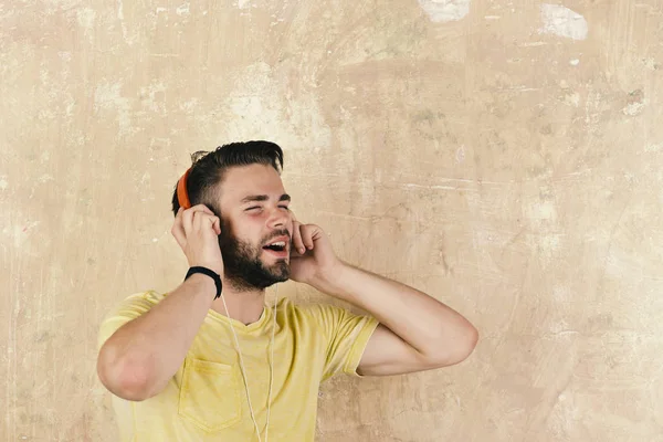 Estilo de vida musical. Dj alegre escuchando canciones a través de auriculares. El hombre europeo se divierte. Americano guapo barbudo chico con auriculares . — Foto de Stock