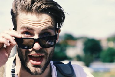 Seyahat ve tatil kavramı. Sakallı adam ve yüz güneş gözlüğü takıyor sürpriz açın