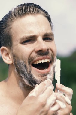 Adam traş köpüğü ile kaplı. Seksi yüzü olan bir erkek. Güzellik ve sağlık kavramı: kıl tıraş olan adam