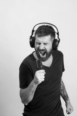 Sakallı DJ kulaklık takıyor. Sakin ol ve müzik konsepti. Şarkıcı sakal ve heyecanlı yüz ile müzik müzik dinliyor