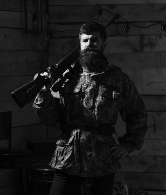 Av hayvanı bekçisi konsepti. Avcı, acımasız hippi, sert suratlı, silahlı ve avlanmaya hazır. Sakallı bir adam kamuflaj kıyafeti giyiyor. Omzunda tüfek taşıyor.