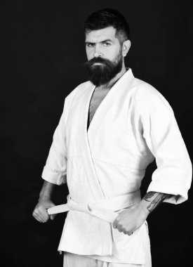 Ciddi ve kendinden emin yüz üniformalı adam karate. Siyah arka plan üzerine beyaz kimono içinde sakallı.
