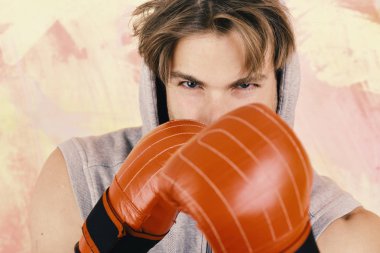 Renkli arka plan üzerinde dağınık saçlı adam. Boksör öfkeli yüz ile trenler yumruk, yakın çekim için