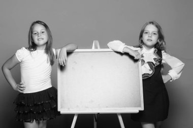 Mavi arka plan üzerinde üniforma okuldaki kızlardan. Eğitim ve okul kavramı. Çocuk tahtaya yalın