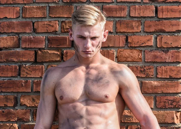 Builder with sexy muscular torso, brick wall on background. Athlete with sexy nude torso. Hard worker concept. Builder with strong muscular body covered with dust relaxing — Stock Photo, Image