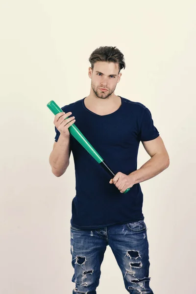 Guy in dark blue tshirt holds bright green bat for baseball. Man with bristle on white background. Guy in blue tshirt holds bright green bat for baseball — Stock Photo, Image