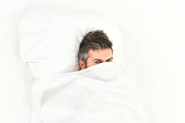 Guy hides face under blanket. Lazy and laziness