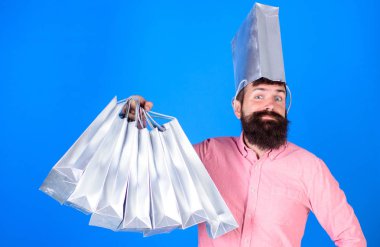 Gümüş çanta satış hakkında delirmek başındaki adam eğlenceli ve sevinç bir kavram. Pembe gömlekli alışveriş yaparken şık sakallı hippi. Sakallı adam ile mavi arka plan üzerinde mevcut paketleri isolalated