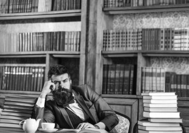 Edebiyat, başarı, düşünceler, hayaller, Kütüphane, eğitim, bilgelik kavramı. Editör Kütüphane ve okuma kitapta oturur. Düşünceli yüz sakallı adam. Akıllı takım elbiseli olgun adam edebiyat hakkında düşünüyor.