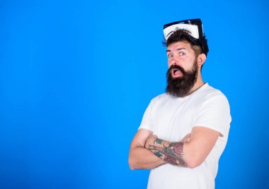 Sakal ve bıyık Vr gözlük, mavi arka plan ile olan adam. Adam Vr gözlük veya baş ile ekran monte. VR teknolojisi kavramı. Ellerini göğsüne, kopya alanı geçti hipster sürpriz yüz tutar
