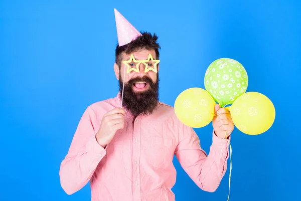 Fröhlicher bärtiger Mann mit breitem Lächeln und Geburtstagskappe. glücklich Hipster mit stylischem Bart und Schnurrbart in rosa Hemd posiert mit Party-Accessoires auf blauem Hintergrund. Party-Performer bei Kinderveranstaltung — Stockfoto