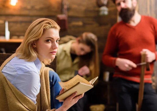 Donna bionda con sguardo sospetto libro di lettura. Donna in camicia blu e jeans che si scalda con coperta di lana beige. Una famiglia che passa del tempo insieme. Ragazza appassionata di letteratura, topo di biblioteca godendo di nuovo romanzo — Foto Stock