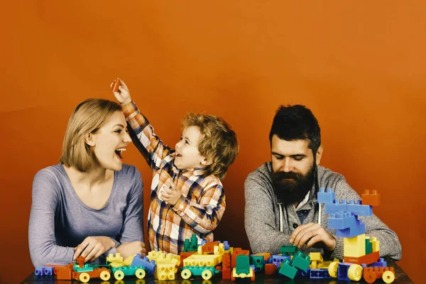 Rodiče a dítě v herně. Rodina s veselou tváří zbudovat barevné stavební bloky — Stock fotografie
