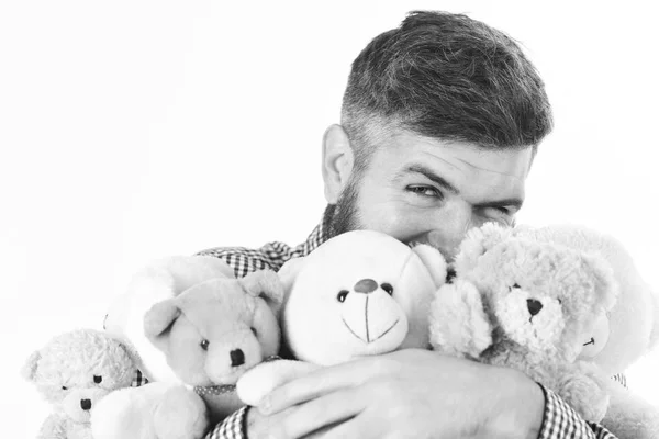 El hombre con la cara feliz sostiene la pila de juguetes suaves, de cerca. Macho con abrazos de barba muchos osos de peluche y peluches . —  Fotos de Stock