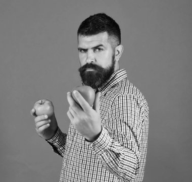 Bahçe ve sonbahar bitkileri kavramı. Çiftçi katı yüz ile taze meyve tutar. Adam hasat sunar