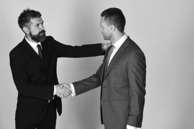 İş ve uzlaşma kavramı. Yöneticiler el sallamak sözleşmesinde ışık gri arka plan üzerinde.