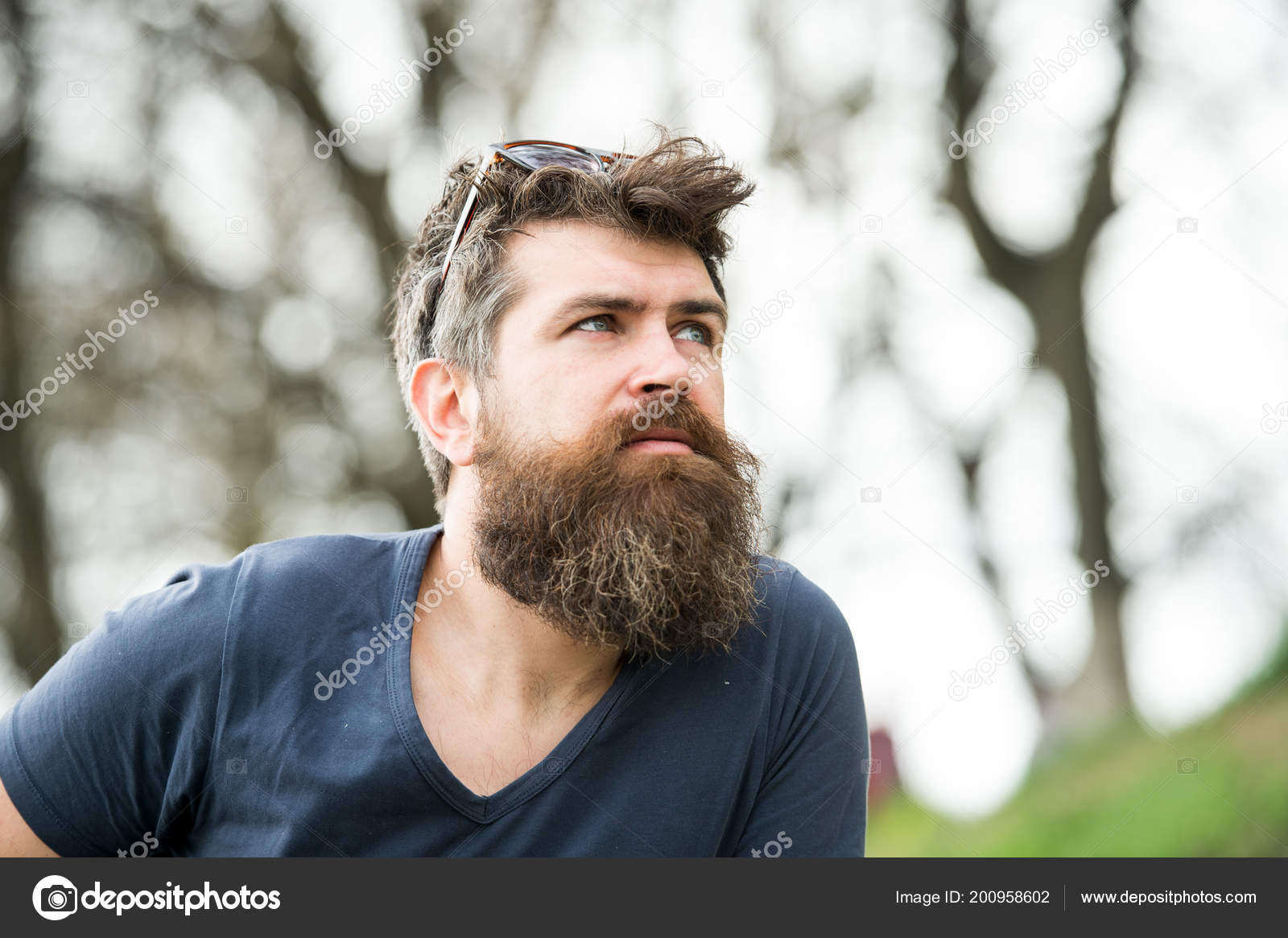 Homme à longue barbe et moustache porte des lunettes de soleil sur