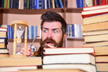 Dostum, bilim adamı kum saati görünüyor. Öğretmen ya da sakal Kitaplığı'nda eğitim ile öğrenci. Adam ciddi ve şok yüz izlerken zaman raflardan, arka planda gidiyor. Zaman akışı kavramı