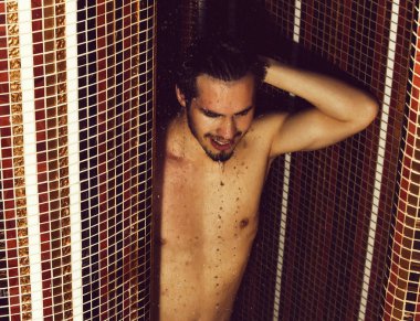 Yakışıklı kaslı seksi adam duşta yıkanıyor.