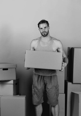 Karton kutular arasında duran ve bir tane tuttuğunu adam. Sakal ve ilgili yüz karton kutu tutan adam