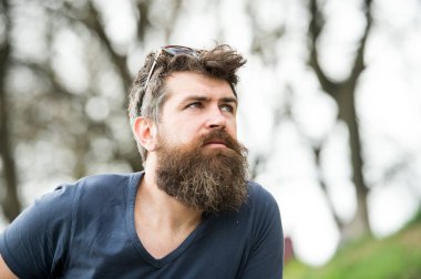 Gözlüklü adam uzun sakal ve bıyık giyer kafa, ufuk arka plan üzerinde. Adam şık sakal ve saç kesimi ile iyi görünüyor. Berber kavramı. Hipster düşünceli yüzündeki gri sakal ile