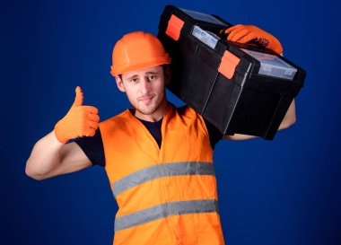 Kask, kask içinde adam araç kutusu tutar ve yukarı hareketi, mavi arka plan gösterir. Onarım istişare kavramı. İşçi, repairer, tamirci, emin yüz taşıyan araç omuz üzerinde Oluşturucu