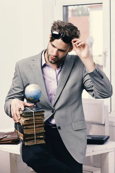 Jó srác szürke öltönyt visel. Üzleti és a tudás fogalma. Üzletember, a halom régi könyvek — Stock Fotó