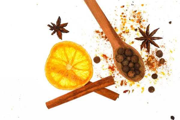 Kit de especiarias de vinho amassado. Kit de especiarias para preparar vinho quente ou bebida quente, close up. Conceito de kit de especiarias. Colher com especiarias, laranja seca, pau de canela, cardamomo e noz-moscada sobre fundo branco — Fotografia de Stock