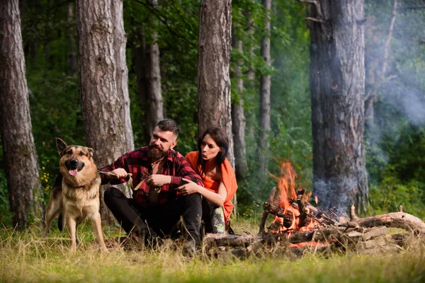 Alman çoban köpeği olan çift şenlik ateşinin yanında.,