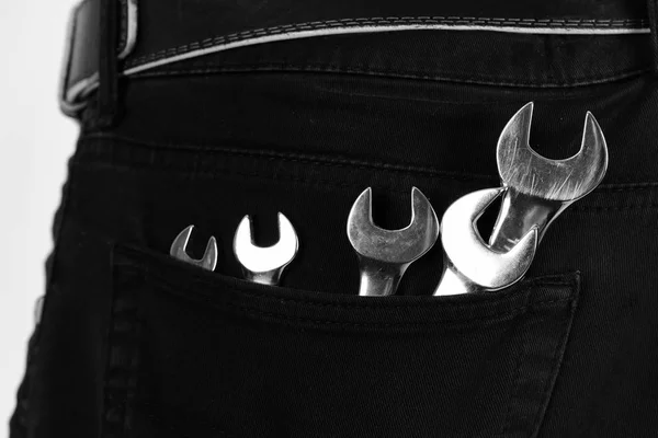 Outils de clé dans la poche du jean sur fond blanc. Équipement de clé en métal. Réparateur ou mécanicien costume — Photo