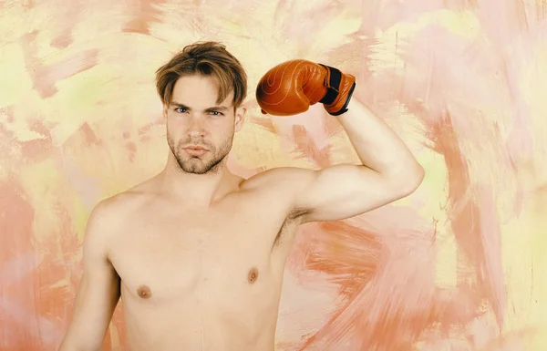 Concepto deportivo y de fuerza. Boxeador con cara seria demostrar bíceps. Chico muestra músculos usando cuero rojo guante de boxeo — Foto de Stock