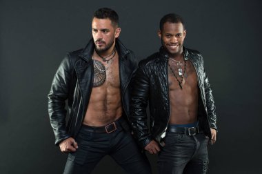 Erkekler gülümseyen yüzler kıl ve dövmeler ile üzerinde. Moda ve stil kavramı. Seksi kas torsolar erkeklerle vahşice bak. Maço kas torsolar ile deri ceketler, koyu arka plan çekici bakmak