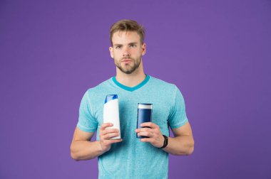 Seçimini yap. Adam şık saç modeli iki şişe hijyenik ürün menekşe arka plan tutar. Ağır yağlı görünümü kaçınarak daha doğal saç göz. Saç yükselterek sorunu ile anlaşma gibi gözünüzün