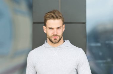 Casual tarzda. Ciddi yüz açık sakallı adam. Temiz hava üzerinde gri sweatshirt içinde maço. Bir dakika mola. Sporty yakışıklı