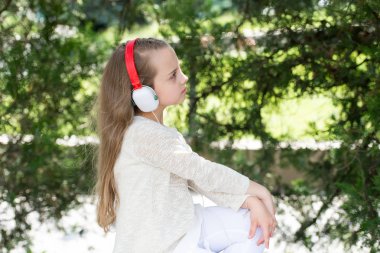 Yaz Park müzik dinle küçük kız. Çocuk müzik kulaklık açık keyfini çıkarın. Moda çocuk ve modern teknoloji. Melodi ses ve mp3. Yaz tatil dinlenme ve eğlence