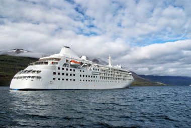 Okyanus gemisi denizde dağ manzarası Sejdisfjordur, İzlanda üzerinde. Cruise gemi denizde dağlar ile bulutlu gökyüzü. Zevk için seyir. Yaz tatil ve gezi. Macera ve keşif