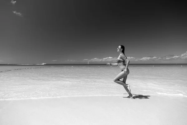 Ragazza in costume da bagno in esecuzione sulla spiaggia di mare — Foto Stock