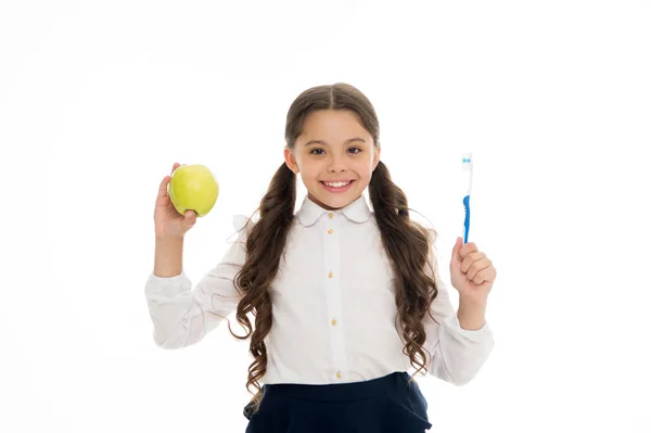 Föda och hälsa. Utveckling av barn. Ett litet barn som ler med tandborste och grönt äpple. Lycklig flicka isolerad på vitt. Tandvård och blekning. Bra vana. Vitamin mat för friska tänder — Stockfoto