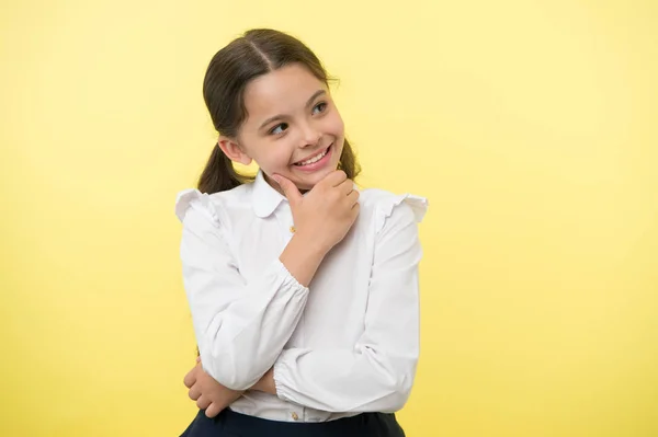 Happy child thinking on yellow background. Little daydreamer girl with cute smile. Lost in thoughts. Your dreams can send you far away. Adorable and smart, copy space — Stock Photo, Image