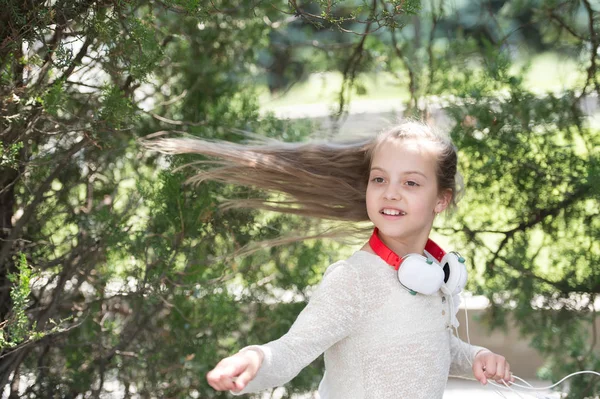 Enfant danseur aux longs cheveux volants. Danse d'enfant à la musique dans le parc d'été. Petite fille profiter de la musique dans les écouteurs en plein air. Mélodie sonore et mp3. Plaisir d'été et joie — Photo