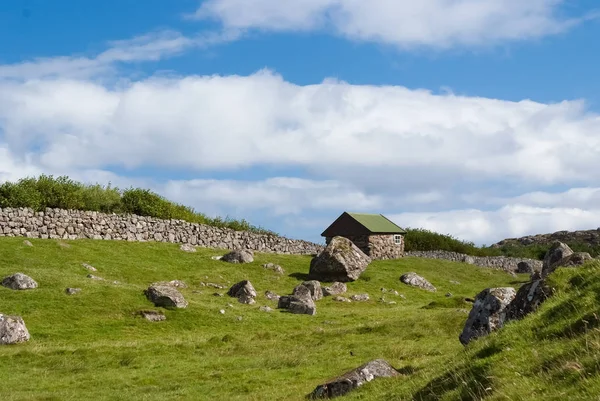 Quinta em Torshavn, Dinamarca. Casa de pedra velha na jarda de fazenda no céu azul nublado. Arquitetura rural típica. Natureza e meio ambiente. Bela paisagem vista. Férias de verão no país — Fotografia de Stock